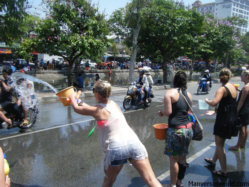 A girl throws water at a motorcyclist for Songkran in Chiang Mai