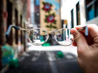 Hand holding glasses in the street