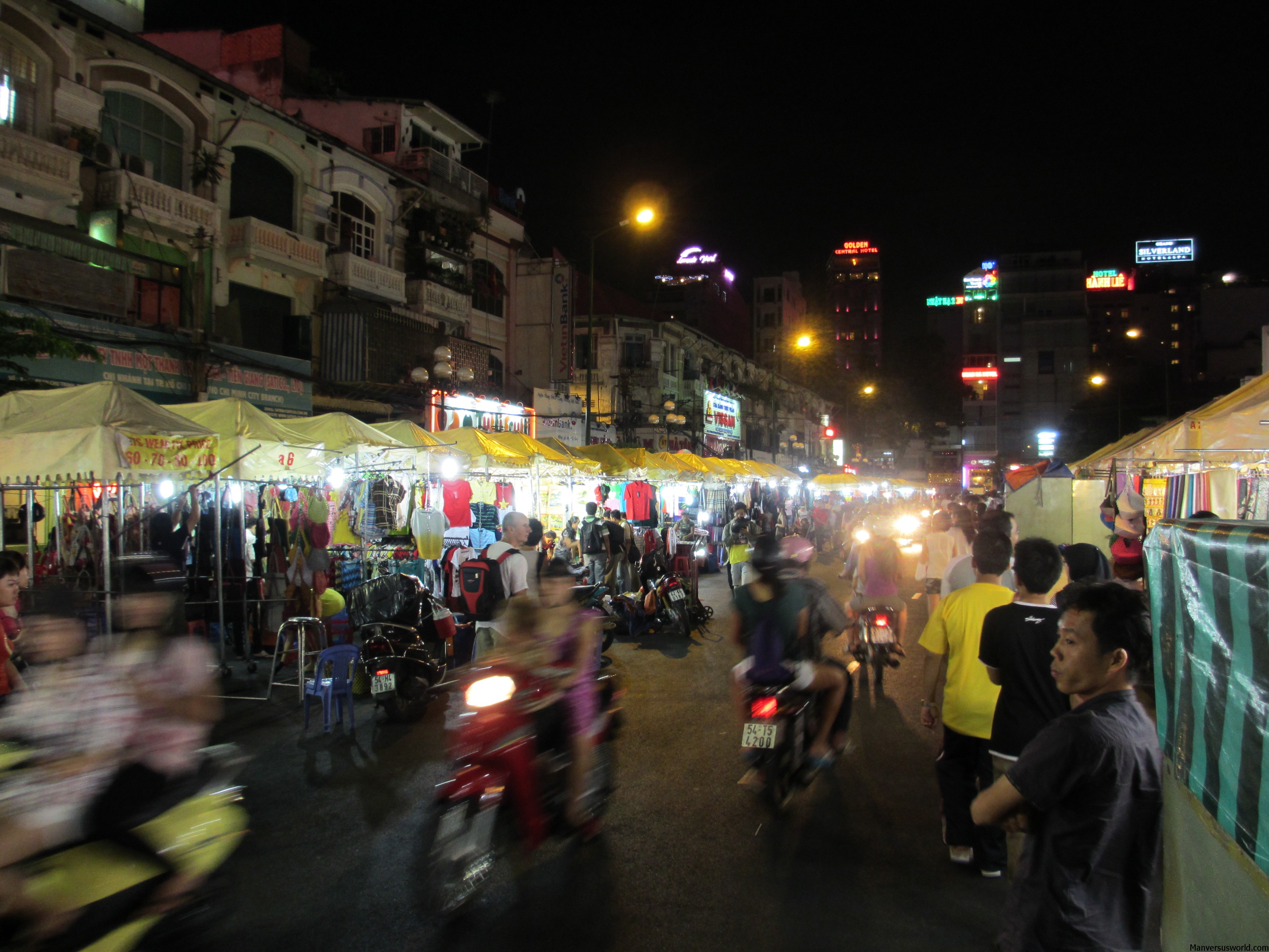 Night market in Ho Chi Minh in Vietnam, with scooters rushing past.