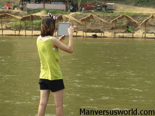 A woman uses an iPad to take a photo while travelling in Asia